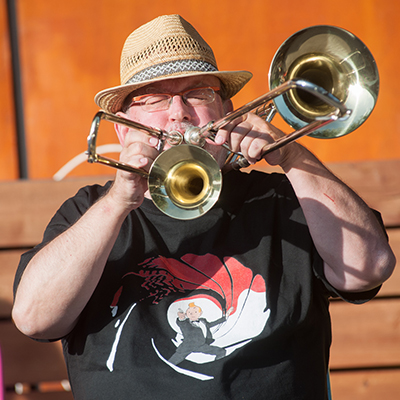 <p>Claude Colpaert jouant deux trombones à la fois.</p>